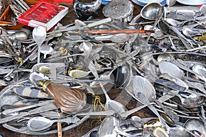 Set of silver and metal spoons and forks in a pile on flea market