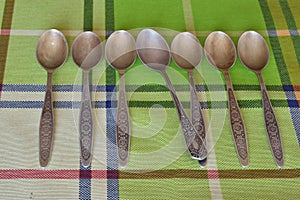 A set of silver teaspoons with a spoon from another set.