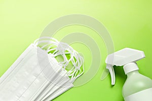 Set of simple white air protection masks on the color surface and Antiseptic solution on yellowish green background