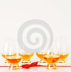 Set of single malt tasting glasses, single malt whisky in a glasses, white background, red bow