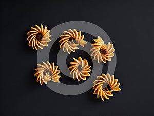 A set of six pastas on a black surface