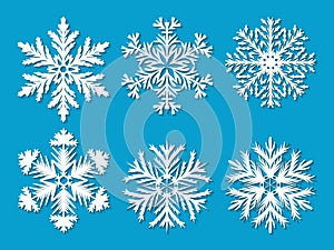 Set of six white paper cut out vector snowflakes on blue background.