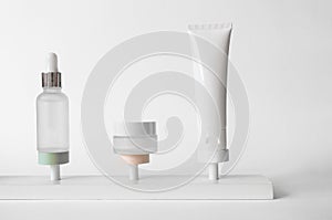 Set of skincare beauty cosmetic products stand on podium on white background, front view. Daily routine care concept. Serum