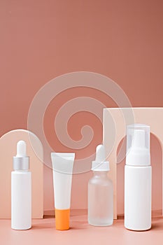 set of skincare containers on a pastel display background