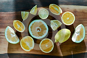 Set of sliced citrus fruits lemon, lime, orange, grapefruit over wooden background. Top view.