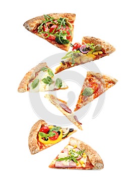 Set with slices of different pizzas falling on background
