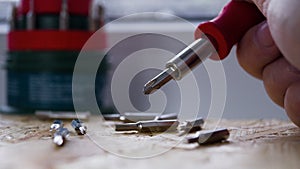 A set of small screwdrivers. A nozzle on a small screwdriver close-up on a light background.