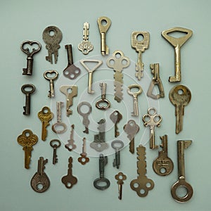 Set of small various metal keys on a light gray background