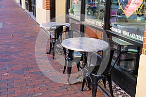 A set of small white tables with black metal chairs in front of an ice cream shop at Atlantic Station photo