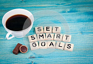 Set smart goals. Coffee mug and wooden letters on wooden background