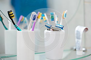 a set of some colorful toothbrushes razor blades on the shelf in bathroom, personal accessories