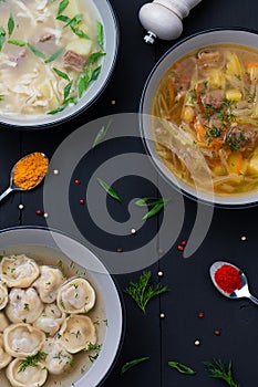 Set soups on black wooden background. Top view