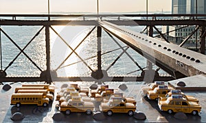 a set of souvenirs in the shape of yellow taxis on the metal structure of the Brooklyn Bridge