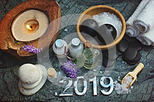 Set for spa procedures in 2019, bath salt and massage oil along with candles and white towels, there are also bian stones for mass