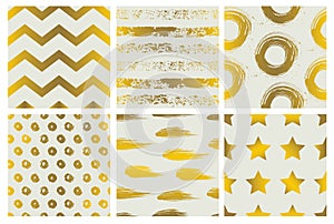 Set of spectacular patterns with gold hand drawn elements on light background.