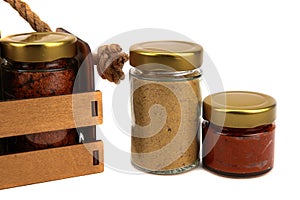 A set of spices in glass jars, packed in a wooden box with a rope handle