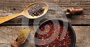 A set of spices and herbs. Indian cuisine. Pepper, salt, paprika, basil, turmeric. On a black wooden background. Top view