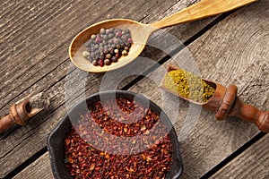 A set of spices and herbs. Indian cuisine. Pepper, salt, paprika, basil, turmeric. On a black wooden background. Top view