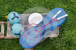 A set of sports items for entertainment. Footballs, badminton rackets, frisbees. Items for sports.