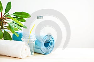 Set for sports. Yoga mat towel and a bottle of water on a light background The concept of a healthy lifestyle Copy space