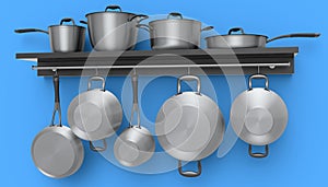 Set of stewpot, frying pan and chrome plated cookware hanging on shelf on blue