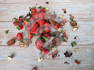 Set of strawberries on a white table with dry leaves