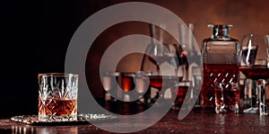 Set of strong alcoholic beverages in glasses on a brown background