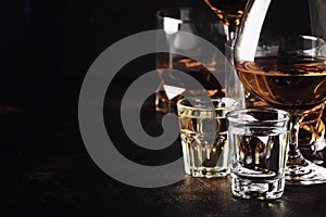 Set of strong alcoholic drinks in glasses and shot glass in assortent: vodka, rum, cognac, tequila, brandy and whiskey. Dark