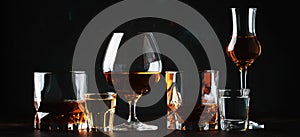 Set of strong alcoholic drinks in glasses and shot glass in assortent: vodka, rum, cognac, tequila, brandy and whiskey. Dark