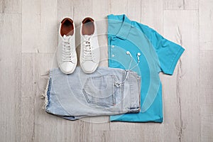 Set of stylish clothes and accessories on wooden floor