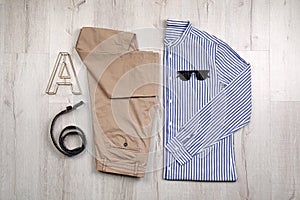 Set of stylish clothes and accessories on wooden floor