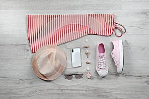 Set of stylish clothes and accessories on wooden floor