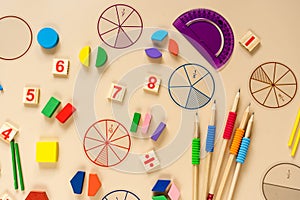 Set of supplies for mathematics and for school. Fractions, rulers, pencils, notepad on beige background. Back to school