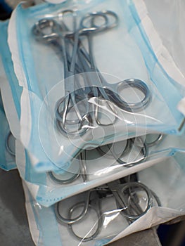 A set of surgical instruments made of medical steel is in a sterile package. Close-up. Several sets of instruments are