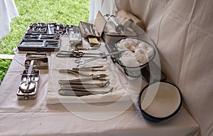 Set of surgical instruments and tools on a white cloth table