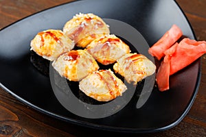 Set sushi on a black triangular plate with ginger closeup.