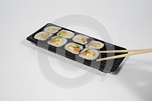 set of sushi with chopsticks in white background