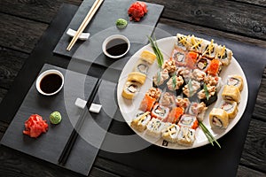 Set of sushi maki and rolls on black rustic wood
