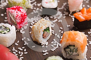 Set of sushi, maki and rolls with sesame on wooden rustic background, closeup