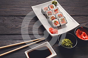 Set of sushi rolls on black wood background, closeup