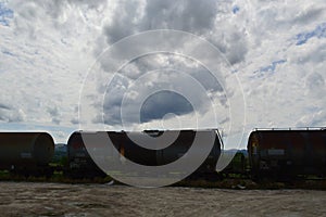 Set of tanks with oil and fuel transport by rail under cloudy sky