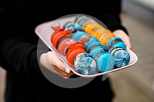 Set of tasty red, blue and orange french macaroons with sweet ganache inside