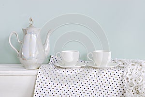 Set of tea cups and ceramic teapot on shelf