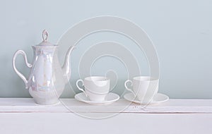 Set of tea cups and  ceramic teapot  on shelf