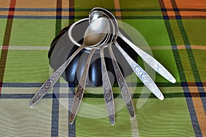 A set of teaspoons stacked on the bottom of an inverted plate.