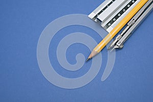 Set of technical drawing tools on a blue background with a copy space