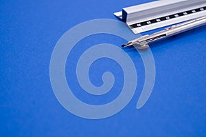 Set of technical drawing tools on a blue background with a copy space