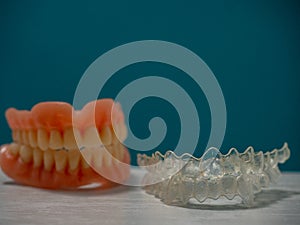 A SET OF TEETH, TOGETHER WITH AN INVISALING BRACES ON A BLUE BACKGROUND photo