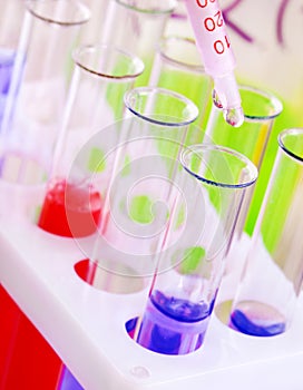 Set of test tubes with blue and red liquid on the desktop