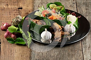 Set of Thai style food with rice, minced pork, papaya salad, pork steak and spare ribs served in banana leaves